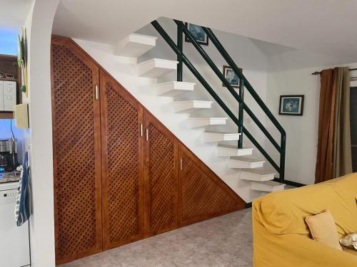 a spiral staircase in a living room with a yellow couch at Beach Townhouse - Murdeira Village in Beirona