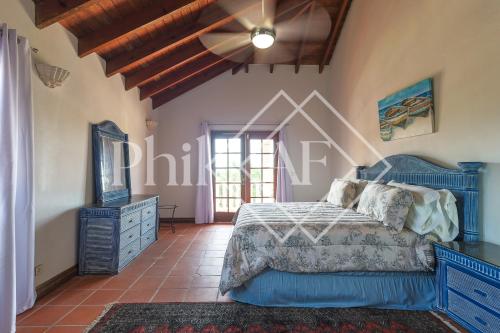 a bedroom with a blue bed and a ceiling fan at Beautiful 5 bed-rooms Villa at Terres Basses in Friar's Bay