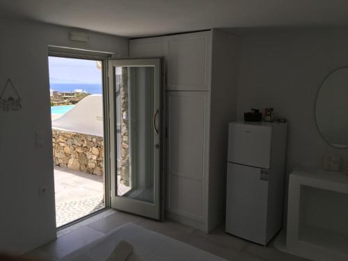 a room with a door open to a view of the ocean at Rineia Complex by Live&Travel in Mikonos
