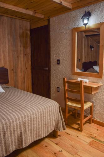 a bedroom with a bed and a desk and a mirror at Campestre DAARLU in Huauchinango