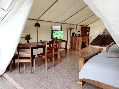 Habitación con mesa de comedor y dormitorio. en Volcano Tenorio Glamping Ranch - 3 Tents, en Rio Celeste