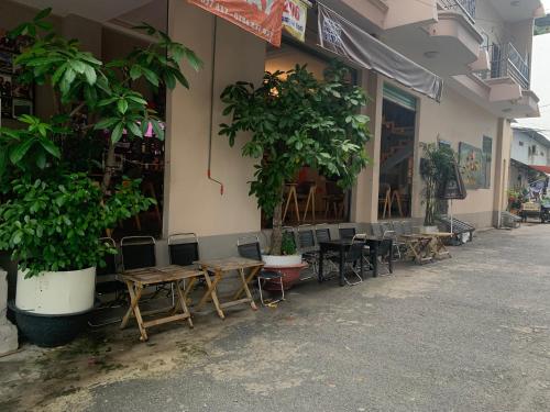 um restaurante com mesas e cadeiras em frente a um edifício em The Vinyl Homestay em Ho Chi Minh