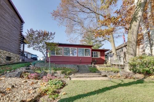 a red house with a tree and some stairs at Lakefront Getaway in Leesburg with Dock and Kayaks! in Leesburg