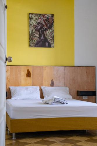 a bedroom with a bed with a painting on the wall at La Palmera Hostel in Cali