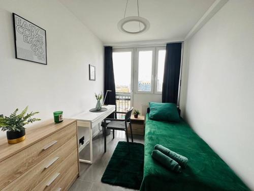sypialnia z zielonym łóżkiem i biurkiem w obiekcie Warsaw City Center Rooms w Warszawie