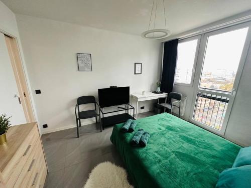 - une chambre avec un lit vert et un bureau dans l'établissement Warsaw City Center Rooms, à Varsovie