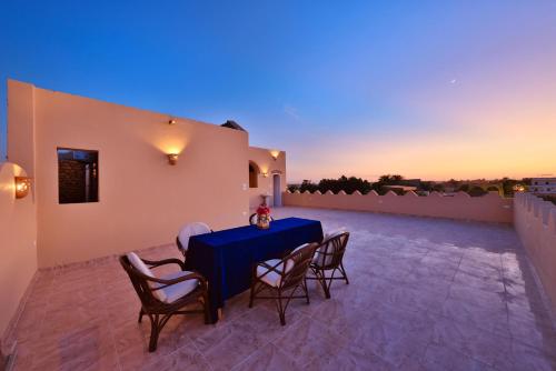 eine Terrasse mit einem blauen Tisch und Stühlen in der Nacht in der Unterkunft El Hanna Valley View in Luxor