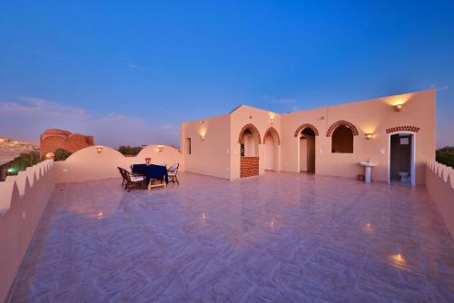 a large patio with a table and chairs at night at El Hanna Valley View in Luxor