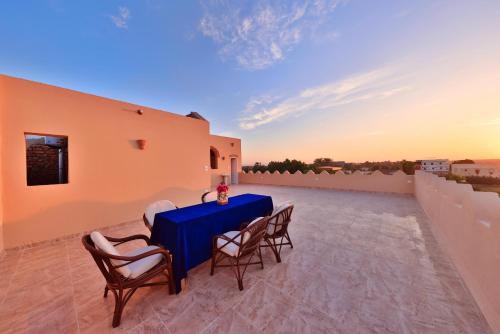einen Tisch und Stühle auf dem Dach eines Hauses in der Unterkunft El Hanna Valley View in Luxor