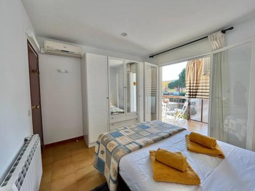1 dormitorio con 1 cama con 2 almohadas amarillas en Encantador apartamento en Playa de Aro, en Playa de Aro