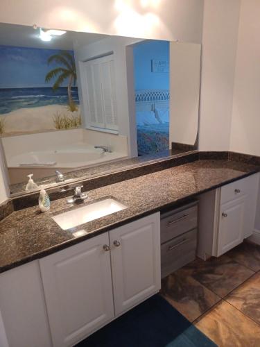 een badkamer met een wastafel en een grote spiegel bij Ocean Walk Resort 911i - 828 in Daytona Beach