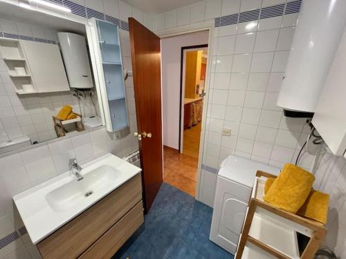 a white bathroom with a sink and a toilet at Encantador apartamento en Playa de Aro in Playa de Aro