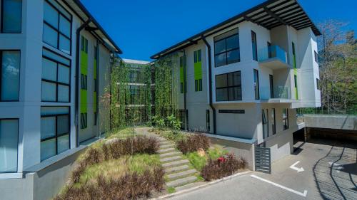 un edificio de apartamentos con jardín en el patio en BEE Suites Santa Ana, en Santa Ana