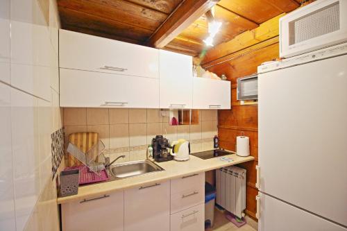 扎科帕內的住宿－Willa Długoszówki，厨房配有白色橱柜、水槽和冰箱。
