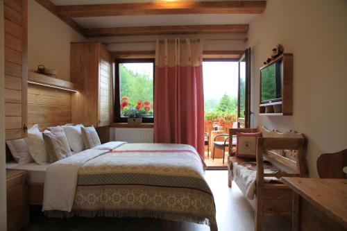 a bedroom with a bed and a large window at Chata Škerda - Zuberec in Zuberec