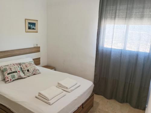 małą sypialnię z łóżkiem z oknem w obiekcie Torres Montecarlo Apartmento con vistas al mar w mieście Benidorm