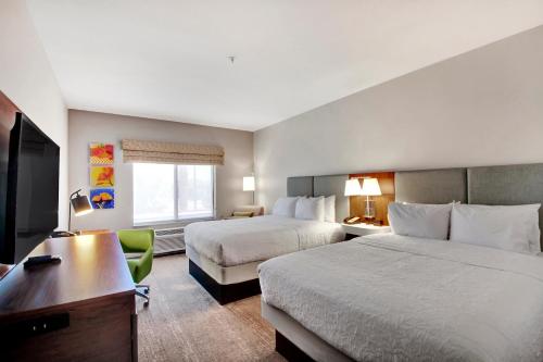 a hotel room with two beds and a desk at Hampton Inn & Suites by Hilton Hemet Menifee Murrieta in Hemet