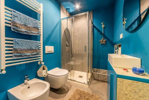 y baño azul con aseo y ducha. en Duomo a 2 fermate - Tiny Apartment in Pta Venezia, en Milán