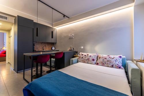 Un pequeño dormitorio con una cama y una cocina. en Duomo a 2 fermate - Tiny Apartment in Pta Venezia, en Milán