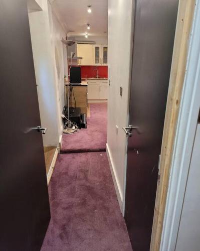 una habitación vacía con un pasillo con alfombra morada en Cosy1 bedroom,sleeps up to4guest en Hornchurch
