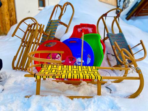 a beach chair sitting in the snow next to other chairs at Chata Škerda - Zuberec in Zuberec