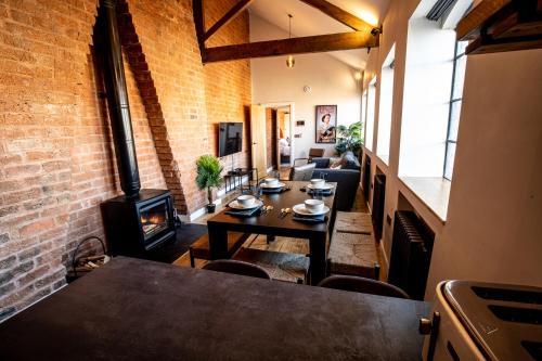 a living room with a brick wall and a wood stove at VIP 3BR Grade2 Luxurious Industrial House with WOOD FIRE, Electric blinds and big Cast iron Windows in the heart of the JQ in Birmingham