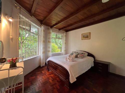1 dormitorio con 1 cama en una habitación con ventanas en Casa vacacional ideal para familias / Los Reyes en Loja