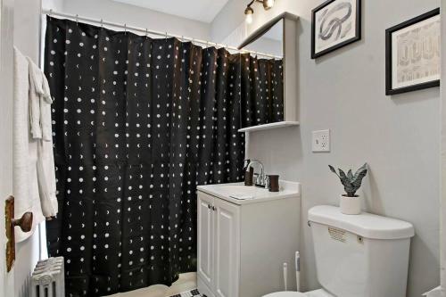 een badkamer met een toilet en een zwart douchegordijn bij 1BR Vibrant & Inviting Apt in Chicago - Montrose 2E in Chicago