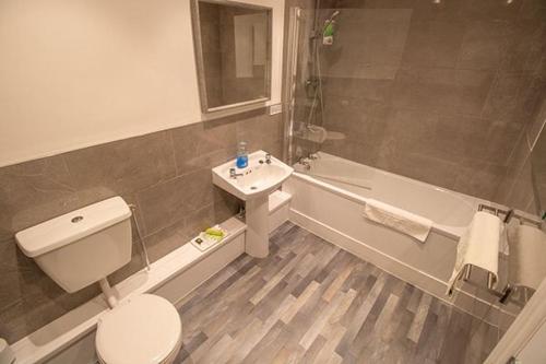 La salle de bains est pourvue de toilettes, d'un lavabo et d'une baignoire. dans l'établissement Boutique Penthouse Apartment in Historic Hull HU1 - sleeps 6, à Hull
