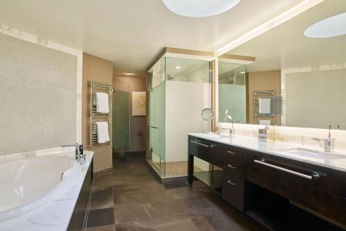 uma grande casa de banho com uma banheira e um lavatório e uma banheira em The Westin Kansas City at Crown Center em Kansas City
