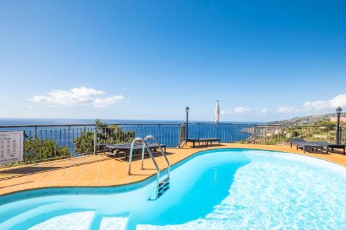 a swimming pool with a view of the ocean at Vila Brava Cottage in Ribeira Brava