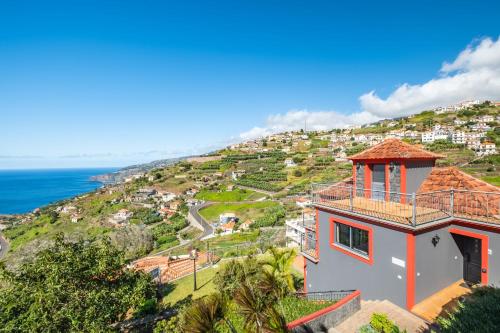 a house on a hill next to the ocean at Vila Brava Cottage in Ribeira Brava