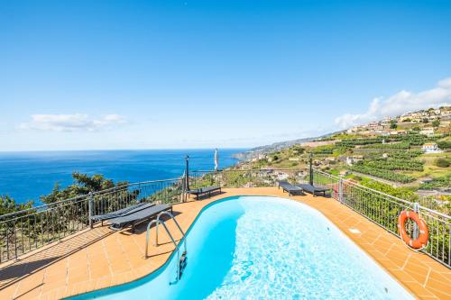 a swimming pool with a view of the ocean at Vila Brava Cottage in Ribeira Brava