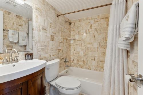 a bathroom with a toilet and a sink and a bath tub at 427 E Miami Ave, Unit 509 in Wildwood Crest