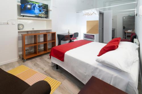 una camera da letto con un grande letto bianco con cuscini rossi di Don Víctor a Salamanca