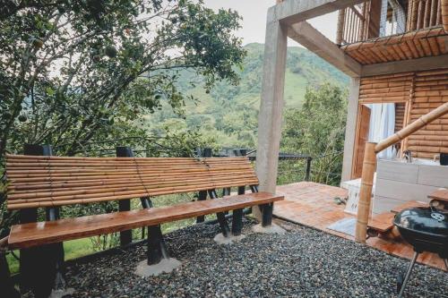 a wooden bench sitting on top of a deck at Cabaña campestre para parejas o grupos in Manizales