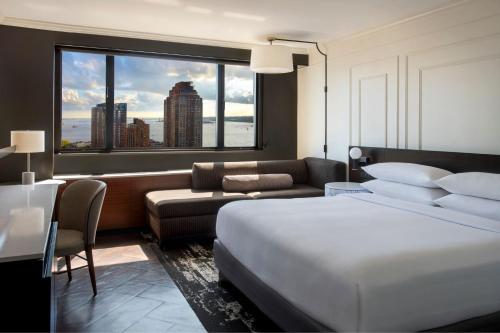 a hotel room with a bed and a large window at New York Marriott Downtown in New York