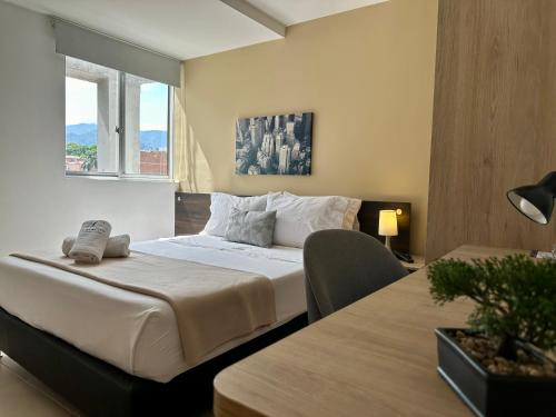 a hotel room with a bed and a window at Laureles Guest House LGH Hotel in Medellín