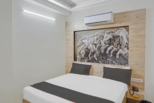 Schlafzimmer mit einem Bett mit Wandgemälde in der Unterkunft Super Collection O Hotel Sundew in Jaipur