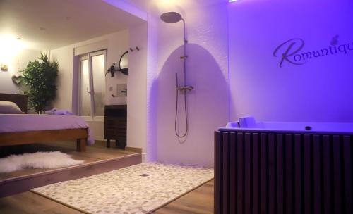 a bathroom with a purple room with a shower and a tub at Love room Unique - Sauna / Jacuzzi in Charleville-Mézières