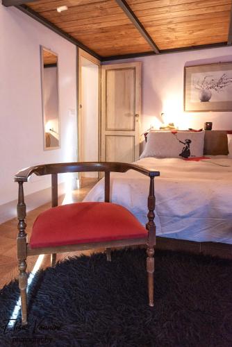 a bed with a red bench in a bedroom at La Mi Casina Toscana in Palaia