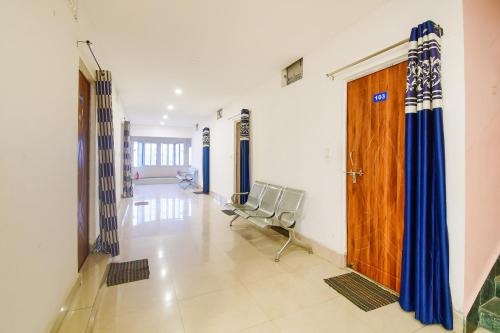 a hospital hallway with a chair and a wooden door at Flagship 85554 Hotel Premium Hari in Jamshedpur