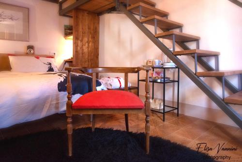 a bedroom with a bed and a red chair at La Mi Casina Toscana in Palaia