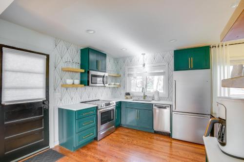 a kitchen with green cabinets and a white refrigerator at Dreamy St Charles Retreat with Furnished Patio! in St. Charles