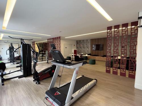 a gym with a treadmill and a elliptical machine in a room at Studios Modernos Totalmente Mobiliados com Academia Próximo a Metrô Parque Ibirapuera e Hospitais in Sao Paulo