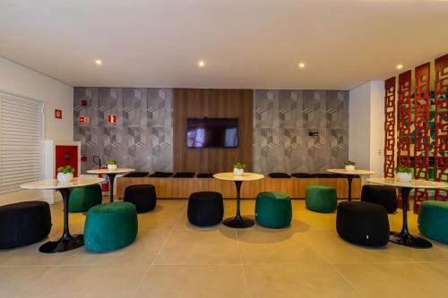 a restaurant with tables and chairs and a couch at Studios Modernos Totalmente Mobiliados com Academia Próximo a Metrô Parque Ibirapuera e Hospitais in Sao Paulo