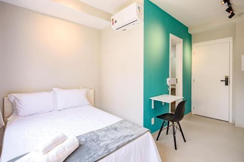 a bedroom with a white bed and a chair at Studios Modernos Totalmente Mobiliados com Academia Próximo a Metrô Parque Ibirapuera e Hospitais in Sao Paulo