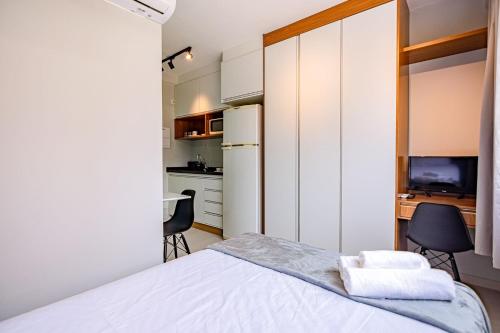 a small bedroom with a bed and a kitchen at Studios Modernos Totalmente Mobiliados com Academia Próximo a Metrô Parque Ibirapuera e Hospitais in Sao Paulo