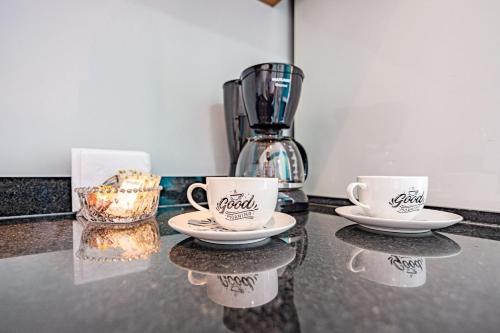two coffee cups on a counter with a blender at Studios Modernos Totalmente Mobiliados com Academia Próximo a Metrô Parque Ibirapuera e Hospitais in Sao Paulo