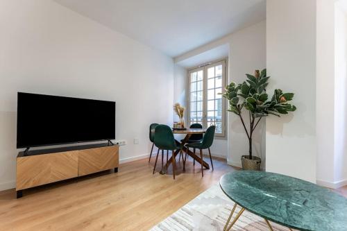 a living room with a flat screen tv and a table at New premium flat - Malaga Center in Málaga